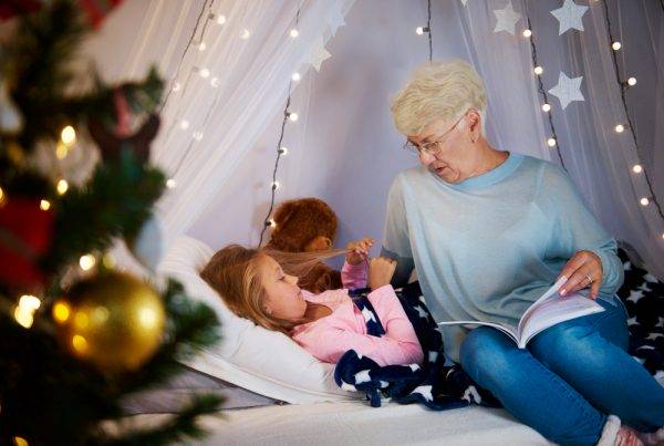 grand-mère lisant un conte thérapeutique à sa petite fille