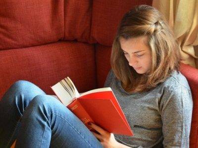 jeune fille dans un canapé lisant un roman adolescent